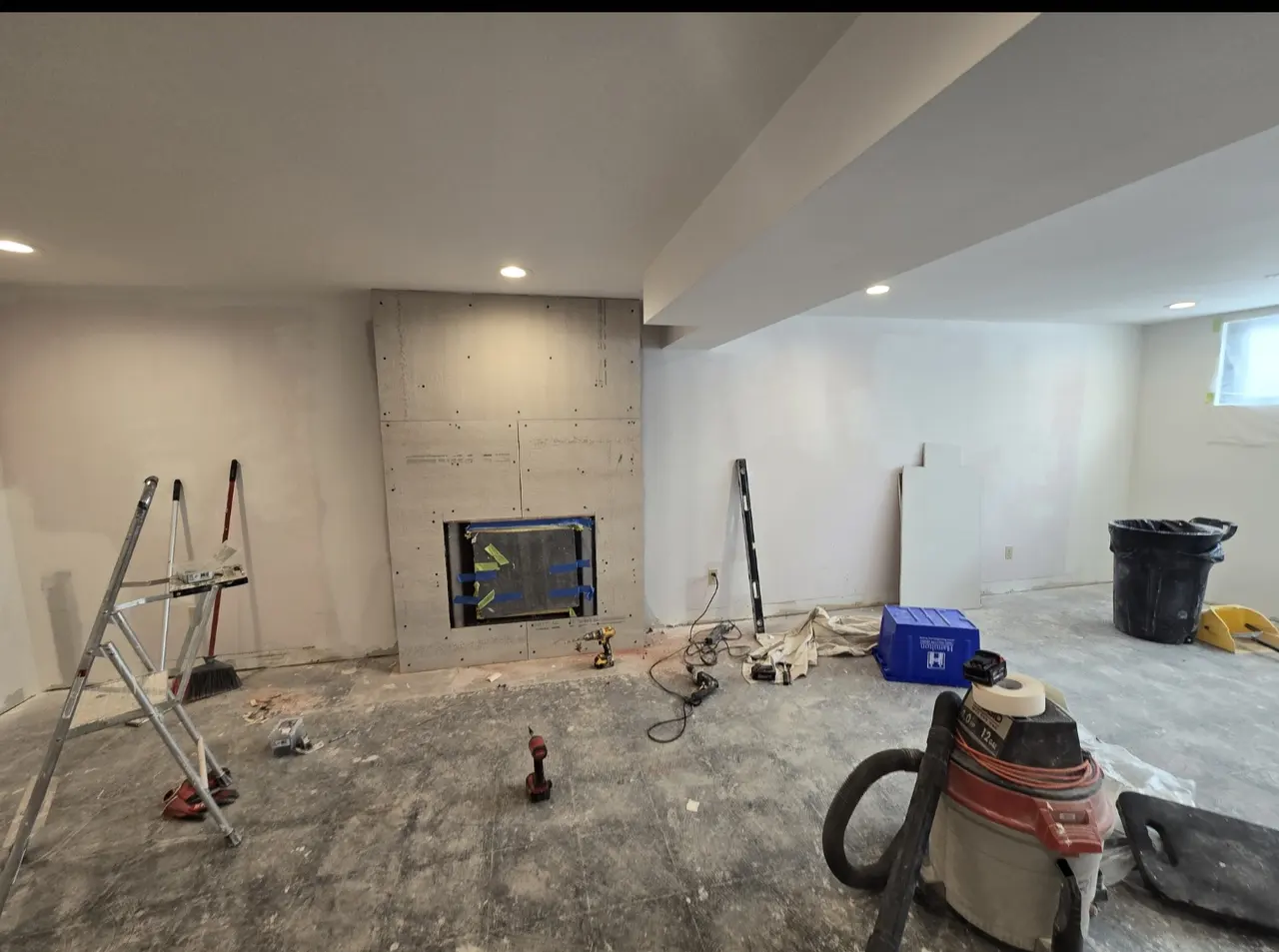 Basement family room during renovation work around the fireplace wall