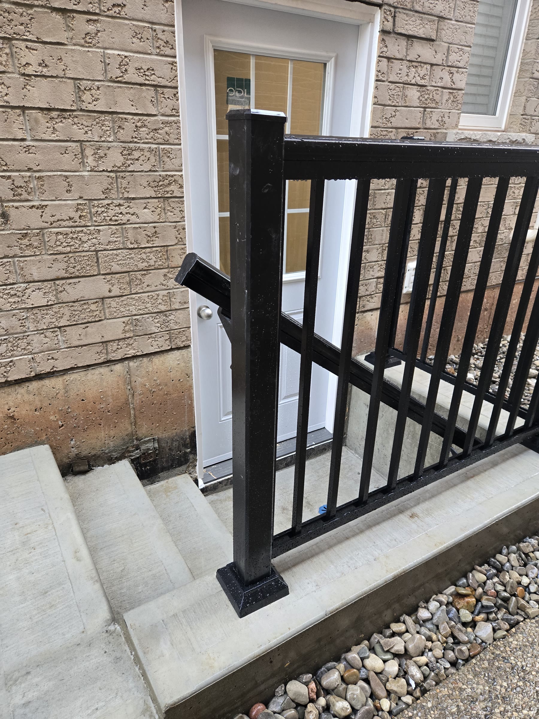 View from the basement entrance showing the concrete landing and guardrail